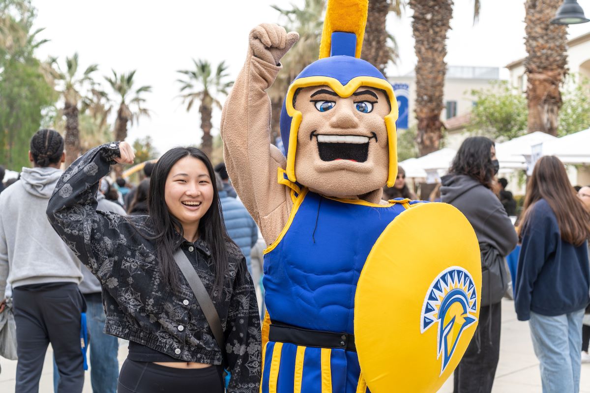 Student and Sammy with one armed raised in an empowered stance.