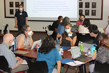 participants are engaged in discussion with background projection on