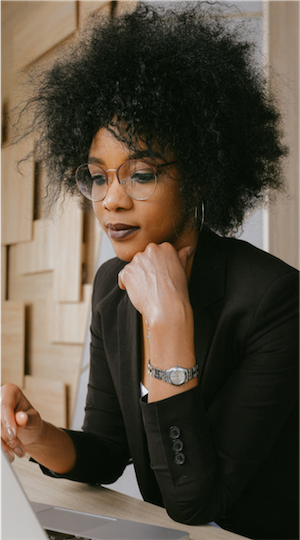 Black woman reading from a laptop computer