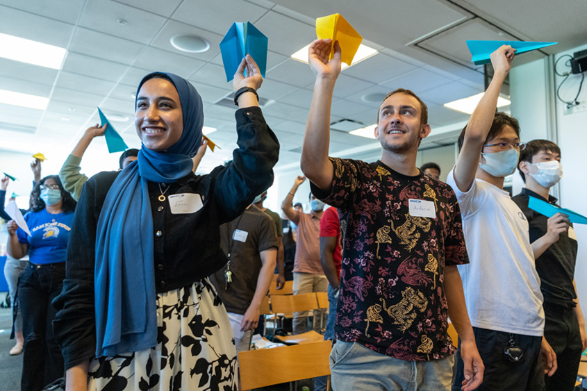 Students throwing paper airplanes.