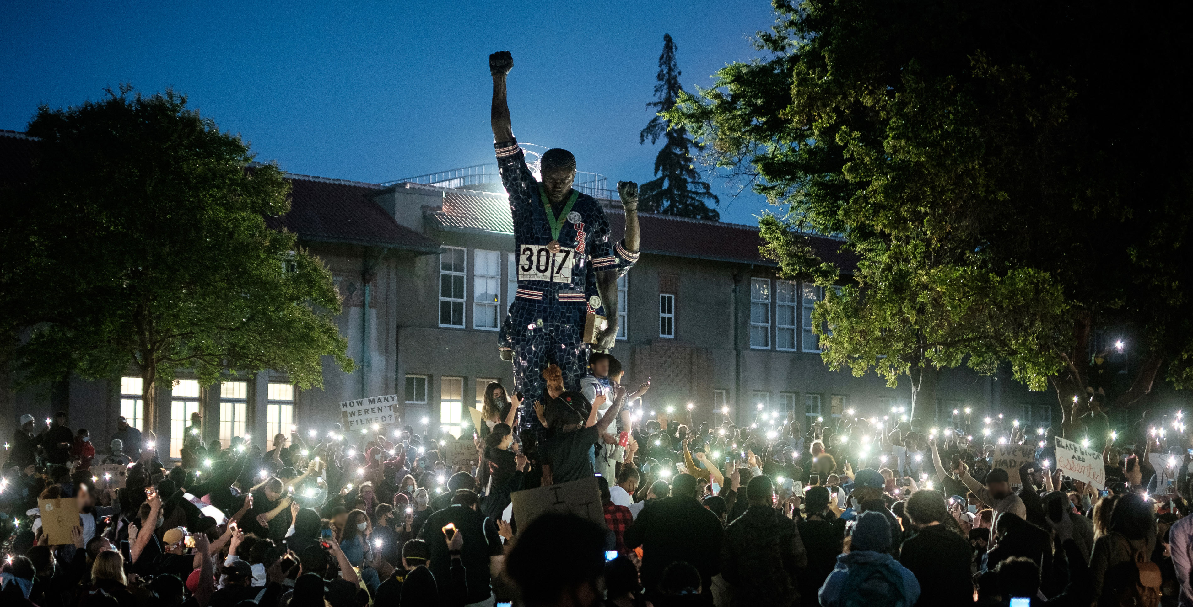 Students gathering around Smith and Carlos statue.