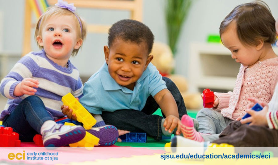 Three diverse toddlers smiling while playing.