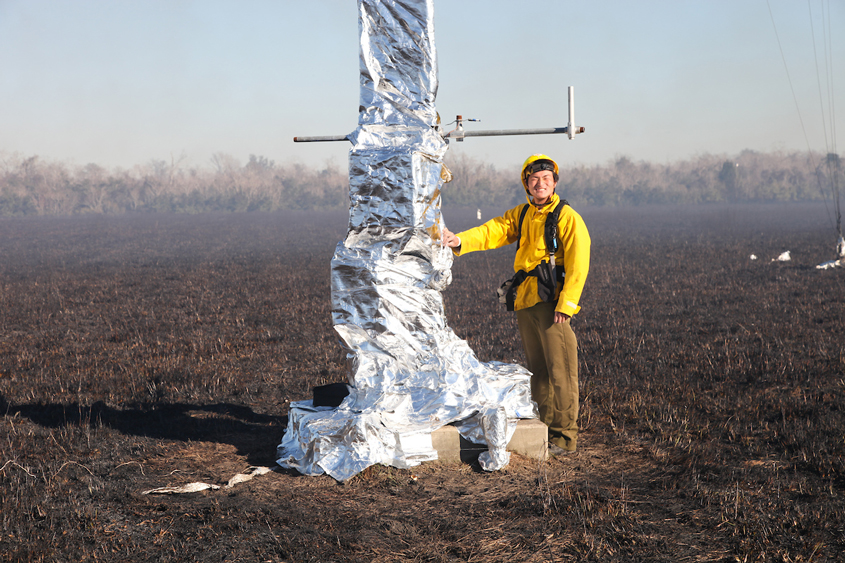 A student in the field with a yellow jacket