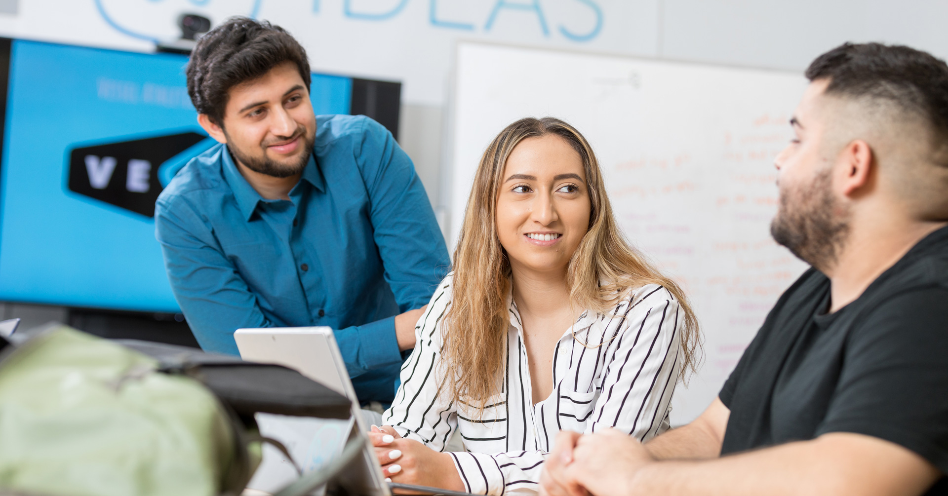 Students gather around at a table in the IDEAS lab.