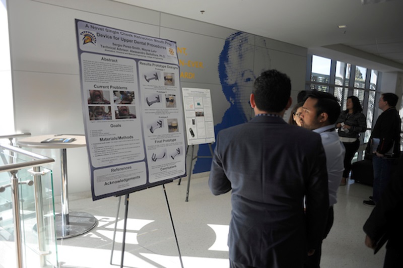 students standing in front of easel at biomed conference