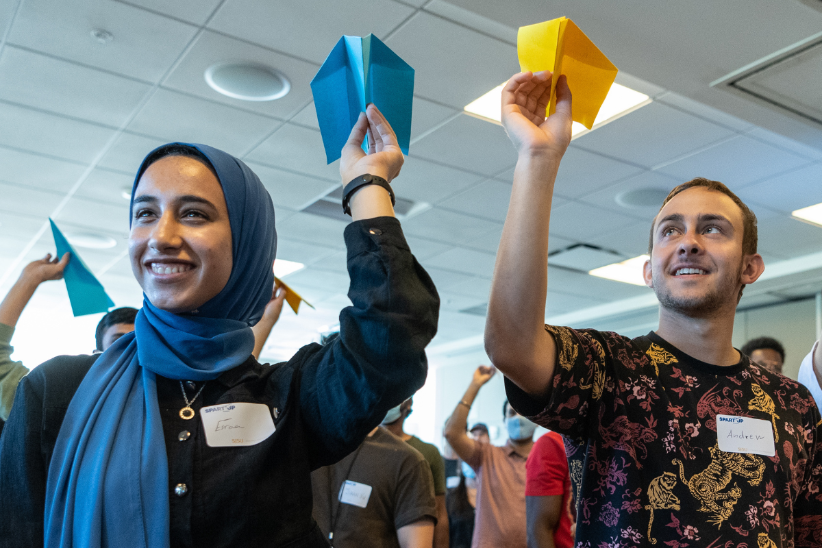 Students throwing paper airplanes.